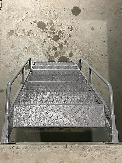 стальная лестница в подвал серого цвета